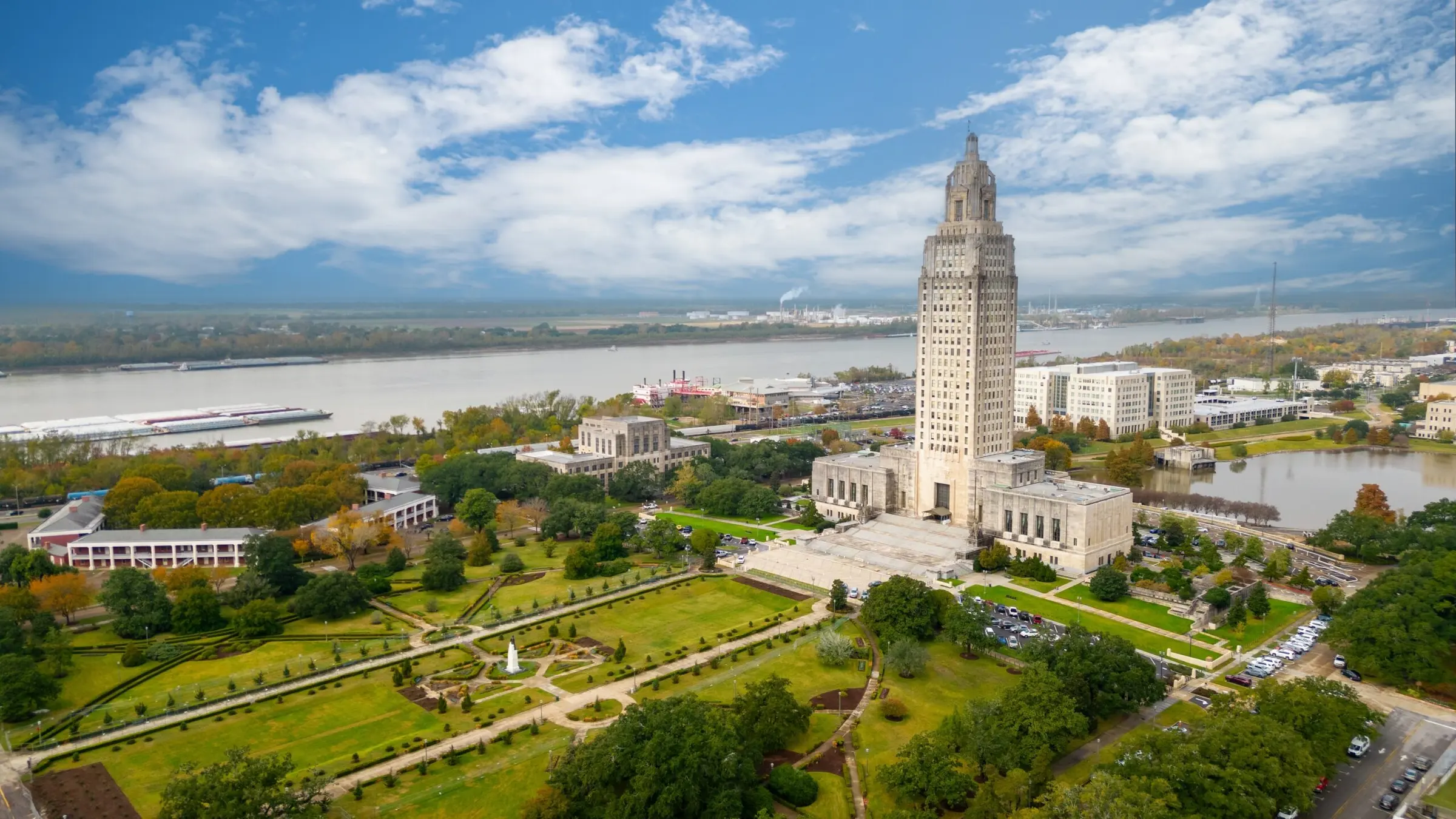 Aerial view of the Louisiana State Capitol and its gardens in Baton Rouge, with the Mississippi River behind